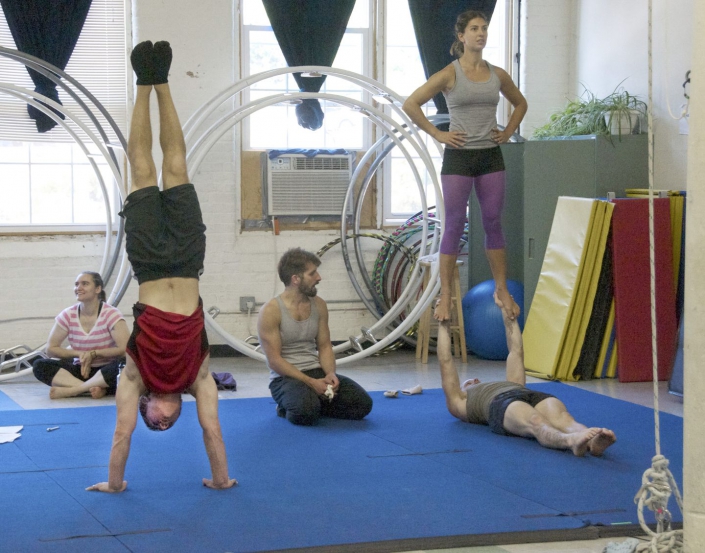people training partner acrobatics with a coach at the NECCA studio in the cotton mill