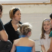 photo of a NECCA coach speaking with several young students